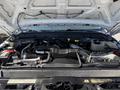 Engine compartment of a 2014 Ford F-250 SD showing various mechanical components and the battery