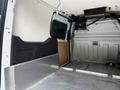 Interior of a 2016 Ford Transit Connect showing a spacious cargo area with metal flooring and storage compartments on the sides