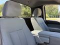 Interior view of a 2014 Ford F-150 showing two front seats with gray cloth upholstery and a center console between them