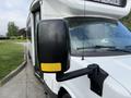 A 2020 Chevrolet Express with a prominent side mirror and a white exterior