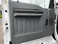 The interior door panel of a 2013 Ford F-650 featuring a textured surface with a handle and a ventilation vent on the right