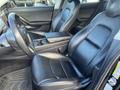 Interior of a 2019 Tesla Model 3 featuring black leather seats with a center console and a steering wheel