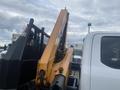 A 2017 Ford F-550 with an attached yellow excavator arm positioned to the side