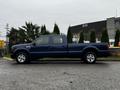 A blue 2008 Ford F-250 SD with a crew cab and chrome wheels parked on a street