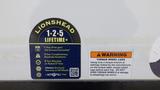 A close-up of a warranty sticker showcasing the Lionshead Lifetime program and warning about torque wheel lugs on a 2021 Grand Design Recreational 311BHS