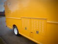 A 2008 Freightliner MT45 Chassis in bright yellow featuring a storage compartment on the side and white wheels