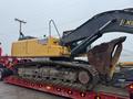 A 2014 John Deere 350G excavator with a yellow and black color scheme featuring a large bucket and tracks is positioned on a flatbed trailer