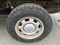 A close-up view of a tire and wheel from a 2010 Ford F-150 showing a rugged tread pattern and a silver wheel rim