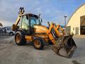 A 2015 Case 590SN backhoe loader with an orange and black color scheme featuring a front bucket and rear excavator arm