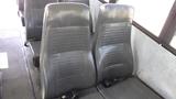 Two black vinyl seats in the interior of a 2014 Freightliner Thomas Bus Diesel with a simple design and ribbed texture