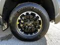 A close-up of a 2023 Toyota Tundra wheel featuring a glossy black rim and a Michelin tire with prominent tread patterns