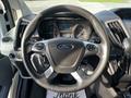 A close-up view of the steering wheel and dashboard of a 2017 Ford Transit displaying the Ford logo and various control buttons