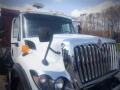 White 2016 International WorkStar 7500 truck with a chrome grille and side mirrors visible in the foreground