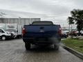 2008 Ford F-250 SD pickup truck viewed from the rear emitting exhaust smoke with the tailgate and rear lights visible