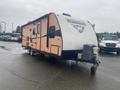 2015 Winnebago Of Indiana Travel Trailer with orange and white exterior featuring the Winnebago logo on the front and equipped with a front hitch for towing