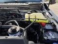 Close-up of the engine compartment of a 2024 Ford F-550 showing the coolant reservoir battery and various engine components