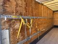 Interior of a 2015 Freightliner M2 106 truck with wooden walls and metal tie rails with yellow and gray straps hanging from them