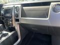 Interior dashboard of a 2014 Ford F-150 featuring a central console with various controls and storage compartments
