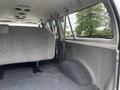 The interior of a 2008 Ford Econoline showing a spacious cargo area with gray upholstery and a large bench seat against the back wall
