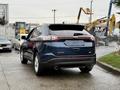 Blue 2017 Ford Edge with sporty design visible from the rear showcasing taillights and dual exhausts