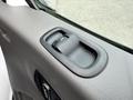 A close-up of the door handle of a 2023 Ford Transit featuring a simple design with a lever for opening the door and textured surface for grip