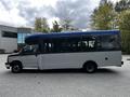 A 2019 Chevrolet Express bus with a blue and white exterior showcasing large windows and a raised roofline