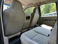 Interior of a 2008 Ford F-550 showing two front seats and a small rear seating area with fabric upholstery