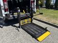 A 2016 RAM Promaster with a lowered wheelchair lift featuring a metal surface and yellow edge for accessibility