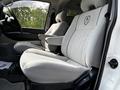 The image shows the front seats of a 2003 Mitsubishi 7 Passenger Van featuring gray upholstery and armrests for added comfort