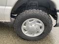 A close-up of a 2011 Ford Econoline tire showcasing a silver wheel and rugged Goodrich off-road tire tread