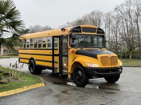 A bright yellow 2013 International 3000 school bus with black accents parked with its door open showcasing its large front windows and distinctive grill design