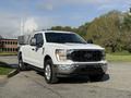 A white 2021 Ford F-150 pickup truck with a black grille and chrome accents parked on a roadway