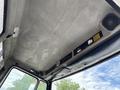 Interior view of a 1998 Freightliner FL80 with a textured ceiling and various panels including a speaker and controls mounted on the overhead console