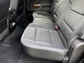 The interior of a 2017 Chevrolet Silverado 1500 featuring a black leather rear bench seat with a fold-down armrest and a spacious layout
