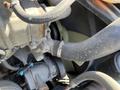 Close-up of a 2022 Freightliner Cascadia engine component featuring various hoses and clamps indicating a complex mechanical assembly