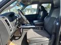 Interior view of a 2011 RAM 1500 featuring a black leather driver's seat and steering wheel with a center console and dashboard elements visible