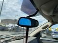 A rearview mirror of a 2009 Dodge Ram 5500 reflecting a blue tint with a red strap hanging down shown from inside the vehicle