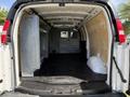 Interior of a 2016 GMC Savana cargo van showing a spacious empty area with a black floor and partial metal partitions along the sides