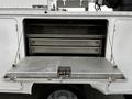 A 2016 Ford F-550 service vehicle with an open rear compartment featuring metal shelves and a flat loading surface