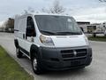 A white 2018 RAM Promaster van with a panel van design featuring a black front bumper and a spacious cargo area visible through the rear doors