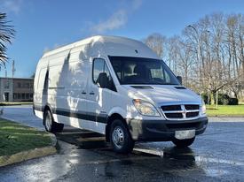 A white 2008 Dodge Sprinter Van parked with a high roof and large cargo space visible in the front view