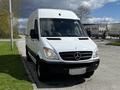 A white 2012 Mercedes-Benz Sprinter van parked on a road with its front facing the camera and the distinctive Mercedes-Benz logo visible on the grille