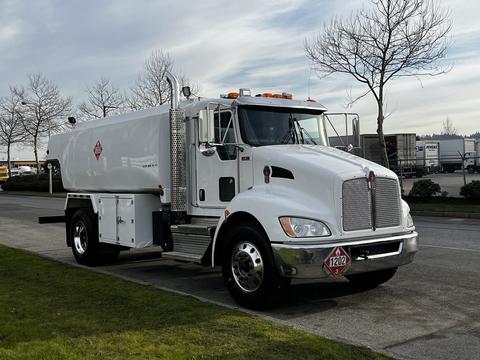 A white 2020 Kenworth T300 truck with a tank body and visible side compartments parked on a street