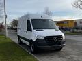 A 2022 Mercedes-Benz Sprinter van in white with a sleek design and prominent front grille parked on the street