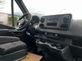 Interior view of a 2021 Mercedes-Benz Sprinter showing the driver's seat steering wheel and dashboard with controls and cup holders