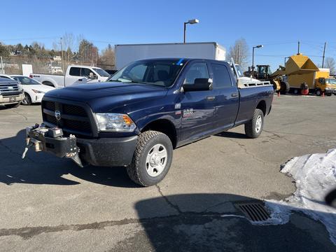 A blue 2014 RAM 3500 pickup truck with a front winch and off-road tires parked in a lot