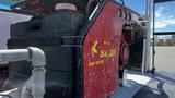 A red air compressor mounted on a truck with a black fuel tank on the side