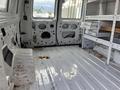 A 2008 Ford Econoline interior showing a spacious cargo area with a white metal floor and shelves along the side panels