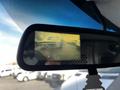 A rearview mirror displaying a backup camera image of a 2015 Chevrolet Express vehicle in motion