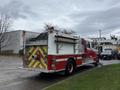 A red and white 2001 Freightliner FL80 fire truck featuring a large rear compartment and reflective safety markings on the back